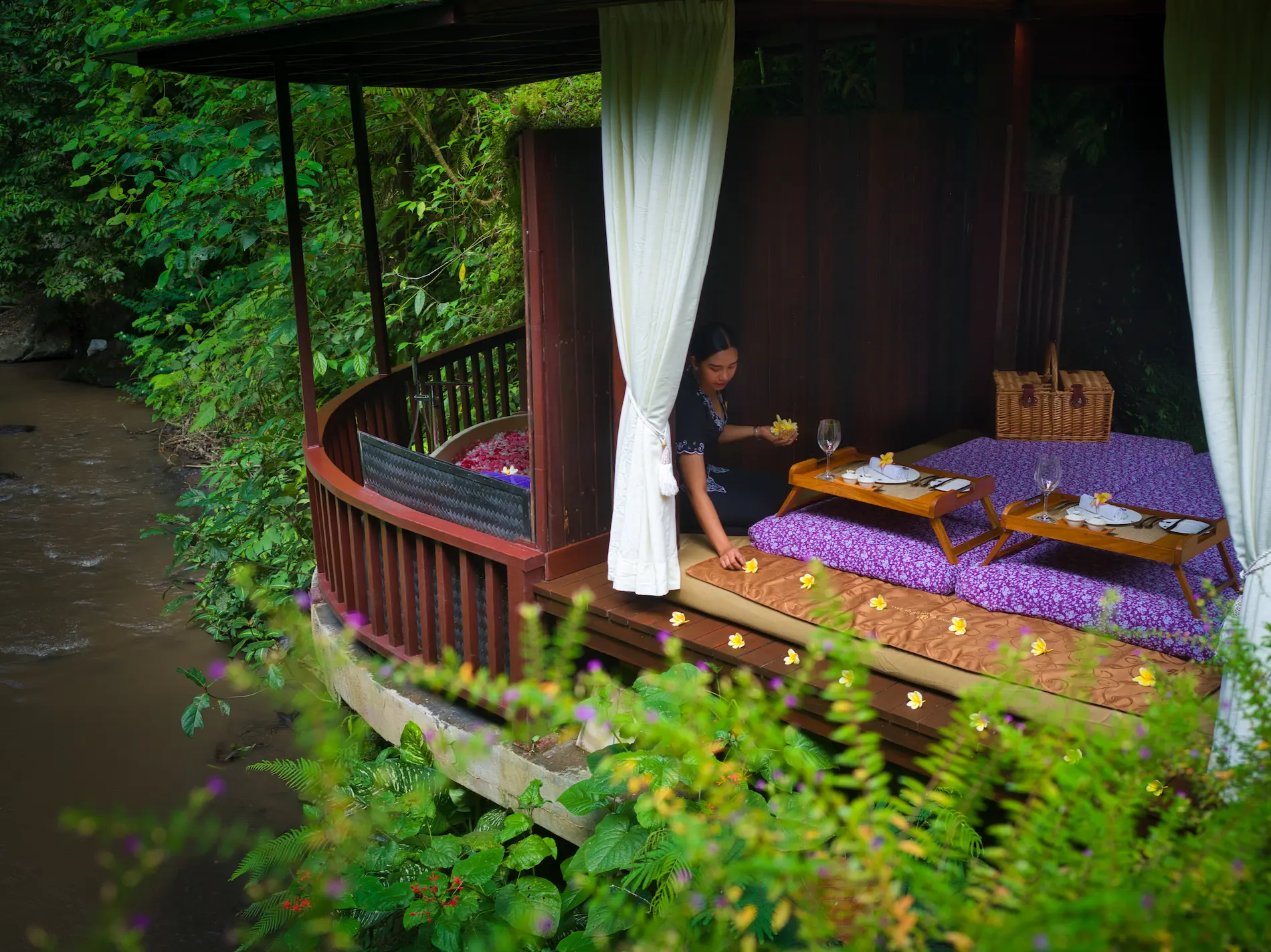Romantic private picnic by the Ayung River in Ubud, Bali, with luxury dining setup surrounded by jungle scenery.